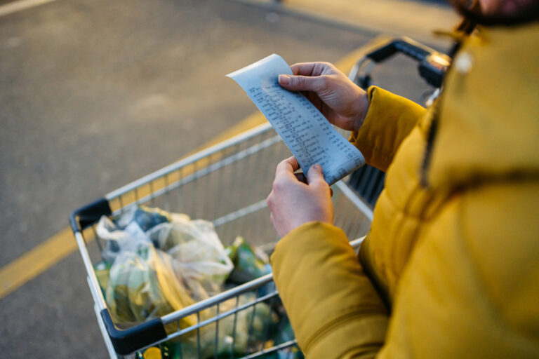 Young Woman Looking At The Receipt From The Grocery Store