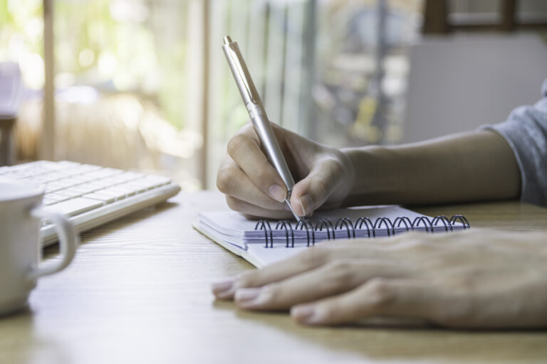 Closeup Hand Of Woman Using Computer And Writing For Business, Finance Concept In Office.