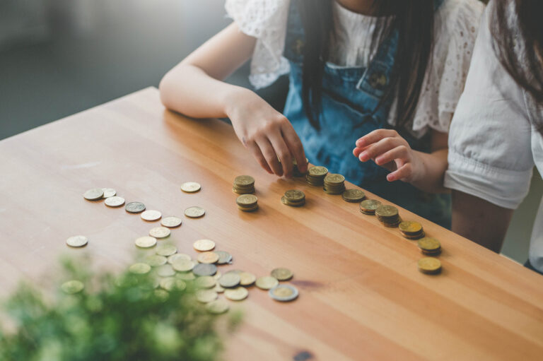 Young Asian Mother And Her Daughter Count Coins